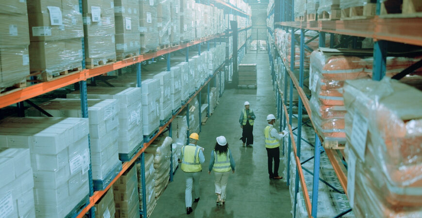 Employees, warehouse and supplier stock for logistics, inventory or inspection by shelves. Above industrial people, distribution and supply chain with safety, busy depot or wholesale storage