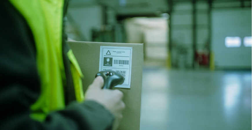 person scanning a shipping label, important for retail logistics