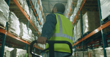 Box, storage and man with trolley in warehouse for supply chain, logistics and inventory distribution. Dropshipping, supplier and picker with stock by shelf for order loading, shipping and delivery