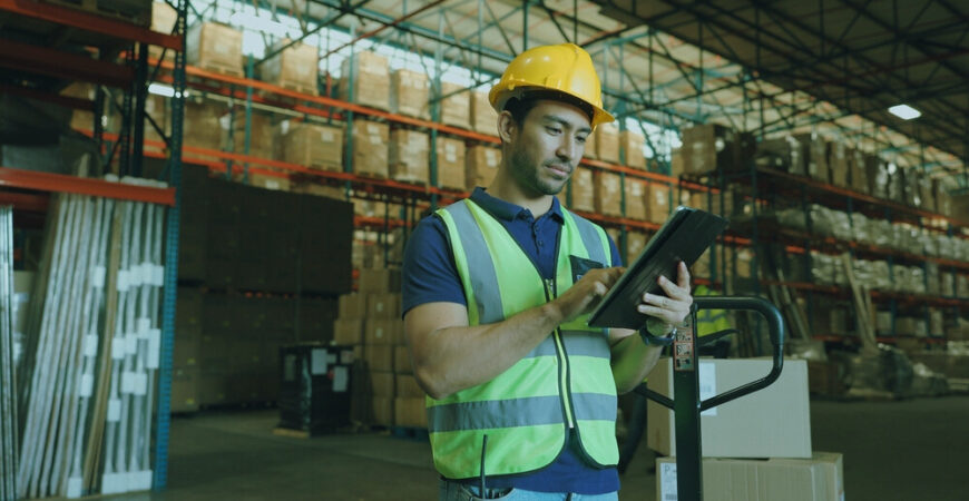 Logistics, man and tablet in warehouse for inventory, stock and price for safety in supply chain or freight. Male person, tech and quality control in industry, shipping in trade for commercial export