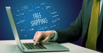 Businessman working on laptop with FREE SHIPPING inscription, online shopping concept
