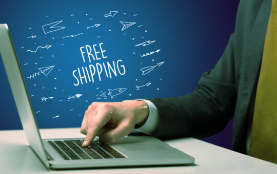 Businessman working on laptop with FREE SHIPPING inscription, online shopping concept