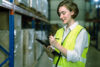 Female warehouse supervisor using tablet for controlling and checking goods supplies on shelves with goods background in warehouse store, Logistic and business export concept