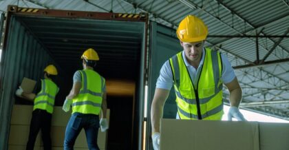 3 Workers hand carry carton box take from 40 feet steel container one by one and stack on floor